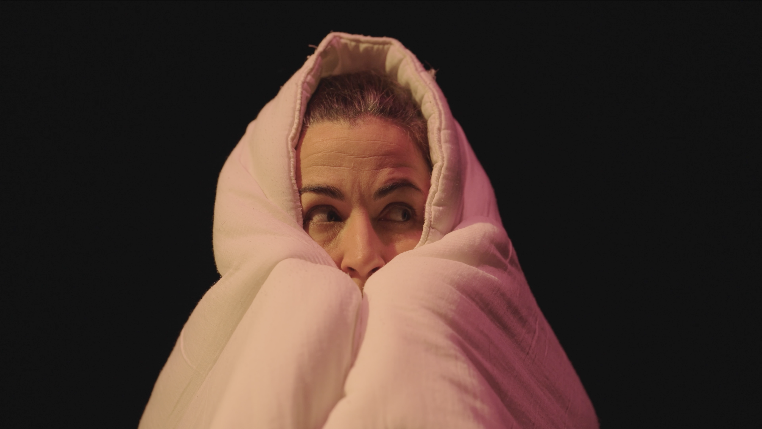 Photo issue d'une représentation du spectacle Je suis Shéhérazade, montrant la comédienne enroulée dans sa couette.